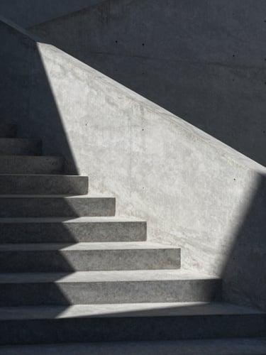 Stark minimalist architectural detail of concrete stairs and sharp geometric shadows under cool daylight, 50mm lens