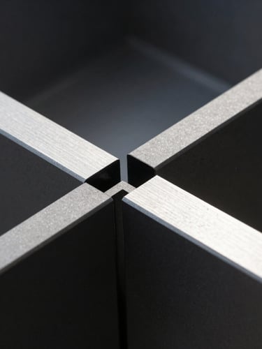 Close-up of matte black aluminum profile joints, sharp geometric lines, high-contrast directional sunlight highlighting metallic textures, 35mm lens