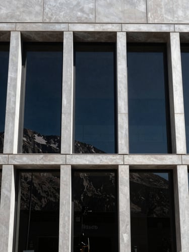 Wide-angle shot of a modern architectural facade in Mendoza with large black aluminum windows, strong mountain sunlight, sharp shadows, 35mm lens