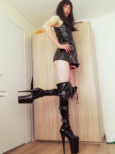 Dutch Sissy Slut Margo wearing a black pvc dress and black thigh high platform boots