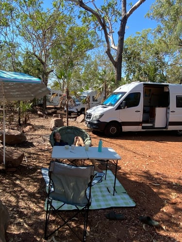 white campervan with table and chairs outside