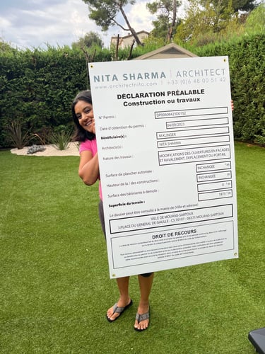 English Architect Nita Sharma holding a permission board