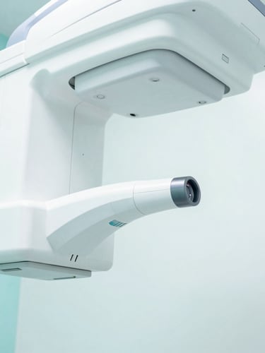 Close-up of a modern dental X-ray machine or digital scanner in a pristine, bright clinic, showcasing advanced technology. Soft studio lighting, clean white and aqua tones.