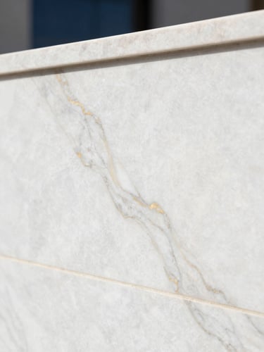 Close-up of premium white marble texture with subtle golden veins, soft diffused natural daylight, architectural precision, clean lines