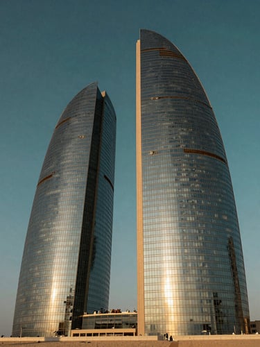 Low-angle architectural photography of Port Baku Towers at golden hour, sunlight reflecting off the glass facade, deep teal sky, sharp detail, 35mm