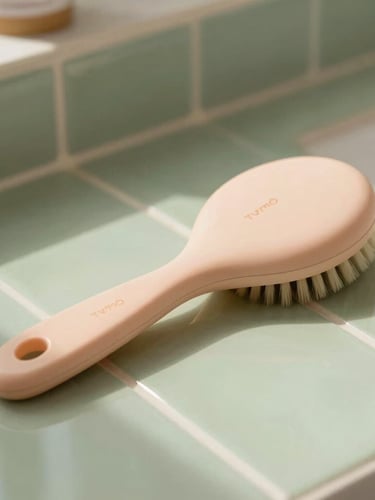 A beautiful close-up of a sleek Tymo styling brush resting on a sage green tiled counter, soft morning light reflecting off its smooth surface