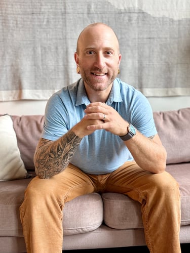 Harrison Blum sitting on coach smiling