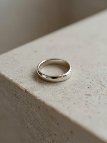 Architectural close-up of a silver structural ring on a travertine stone block, soft natural side-light, muted neutral tones, macro lens, shallow depth of field