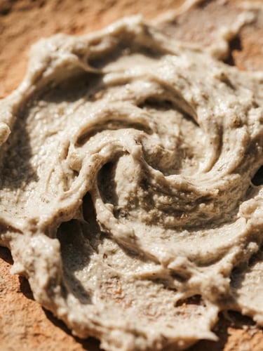 Extreme close-up of thick, raw face cream texture with visible organic swirls, harsh direct sunlight casting dramatic shadows on warm clay background
