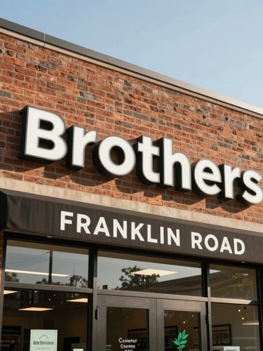 Bright daylight medium shot of the Brothers Cannabis storefront exterior on Franklin Road, professional clean signage, warm brick architecture, clear sky.