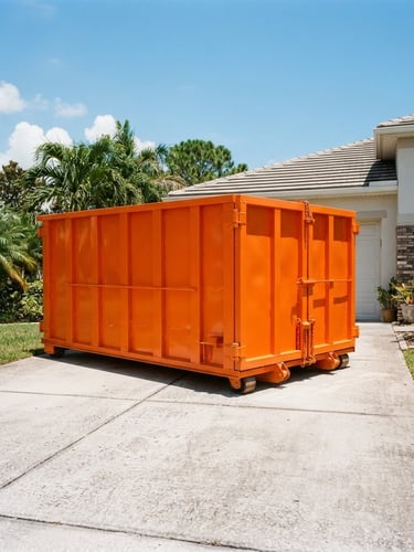 A clean safety-orange roll-off dumpster parked neatly on a concrete residential driveway in bright Florida sunlight, low-angle heroic shot, 35mm lens