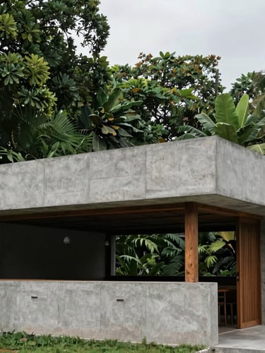 Architectural detail of a modern concrete and timber restaurant pavilion in Kerala, clean geometric lines, surrounded by dense dark green tropical foliage, overcast sky.