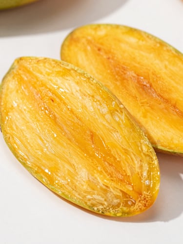 Vibrant macro photography of perfectly sliced dehydrated mangoes on a clean white surface, bright natural daylight, sharp focus on fiber texture, 50mm lens