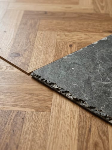 Low-angle close-up of a flawless transition between light oak parquet and modern slate tiles, natural daylight highlighting the precise joints.