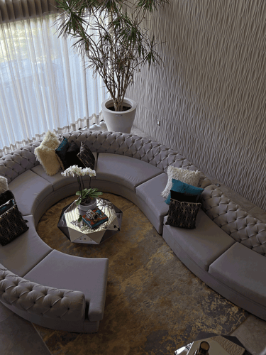 Sala curva desde vista superior, con tapete cálido y mesa central facetada | KARÄNA