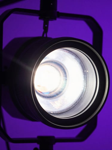 Extreme close-up macro shot of professional concert lighting rigs, lens flare, neon purple backlighting, deep shadows