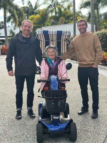 the owners of sunshine coast mobility posing with a happy customer on her rented mobility scooter