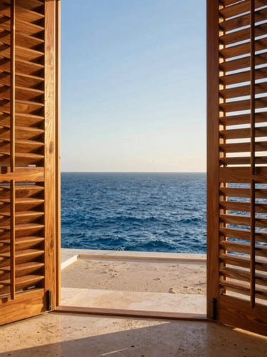 Close-up of high-end parota wood shutters framing a view of the deep blue Sea of Cortez, warm golden-hour light casting soft shadows on travertine floors.