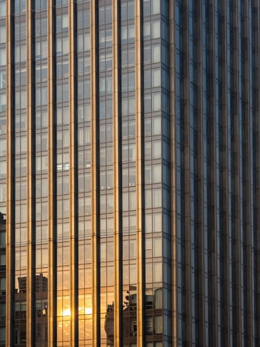 Architectural golden-hour shot of a modern high-rise glass facade in Noida, straight vertical lines, professional editorial style.