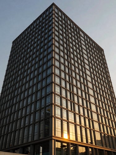 Wide-angle architectural exterior of a modern steel and glass commercial high-rise in Noida, golden-hour sunlight reflecting off structural grid lines