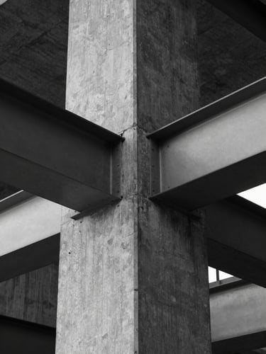 Abstract architectural detail of a concrete pillar and steel beam, high-contrast black and white, clinical lighting, geometric symmetry.