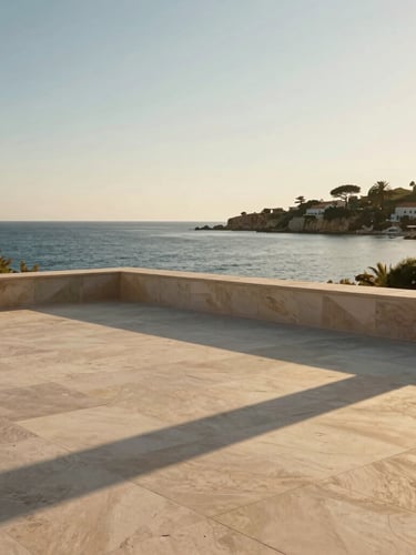 A sun-drenched minimalist stone terrace overlooking a quiet Mediterranean cove at golden hour, low-angle light casting long architectural shadows, no people.