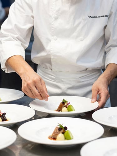 Close-up of a student in a pristine culinary uniform preparing five-star service dishes, bright daylight, sharp focus