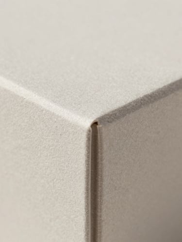 Macro close-up of a premium rigid box corner showing precise foil stamping and matte texture, soft diffused lighting, neutral background