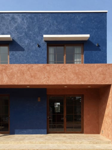Warm architectural photography of a modern Ivorian villa under clear blue sky, bright natural sunlight, rich navy and terracotta tones, sharp focus, 35mm