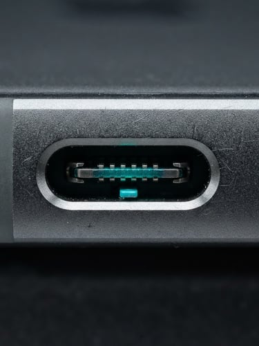 Macro shot of a high-quality smartphone USB-C port, neon teal backlight, clean studio lighting, metallic textures, 35mm lens