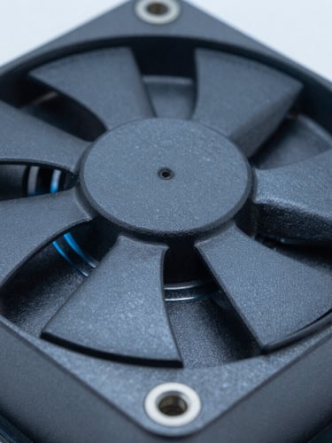 Macro close-up of dark gray anodized aluminum cooling fins on an industrial fanless PC chassis, rugged metallic texture, cool technical lighting with blue undertones, shallow depth of field.