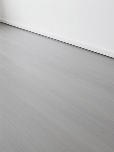 Straight-on architectural shot of a perfectly laid modern grey vinyl floor, clean sharp edges along a minimalist white wall, bright clinical daylight, dust-free surface.