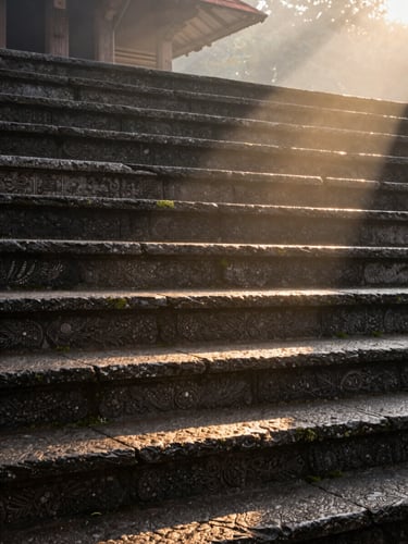 Tall portrait framing of early morning light falling across ancient temple stone steps in Kerala, a single shaft of golden-hour sunlight cutting diagonally across carved granite surface, soft mist in the upper background, extreme close detail on the stone texture and moss, no people present, contemplative and unhurried