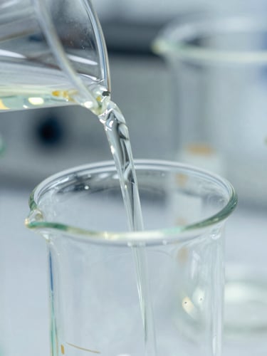 Macro close-up of high-end borosilicate glassware reflecting light, precise pouring of chemical compounds, bright cleanroom lighting, sharp focus, 35mm