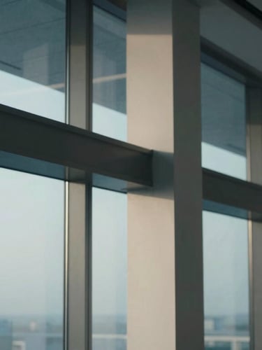 Macro architectural detail of structural steel columns and glass panels in an empty modern corporate boardroom, soft natural light, cool blue-hour tones.