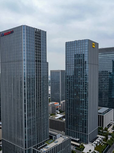 High-angle architectural photography of a modern commercial skyline with structural steel and glass details under cool overcast daylight, wide angle.