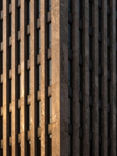 Prestigious architectural photography of a modern Saudi corporate building facade, strong geometric shadows, warm golden-hour window light, minimalist composition