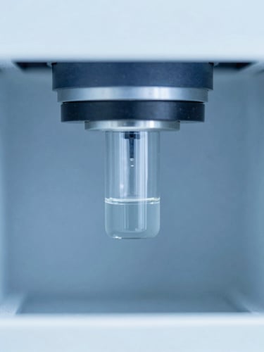Macro shot of a high-precision liquid chromatography system analyzing a pharmaceutical sample in a sterile laboratory, cool bright clinical light, sharp focus on the glass and liquid, blue and white tones.