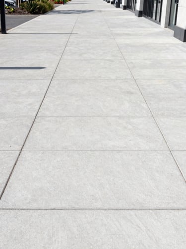 Wide environmental shot of a clean modern commercial retail park walkway in Sheffield, bright natural daylight, crisp focus on restored concrete paving slabs