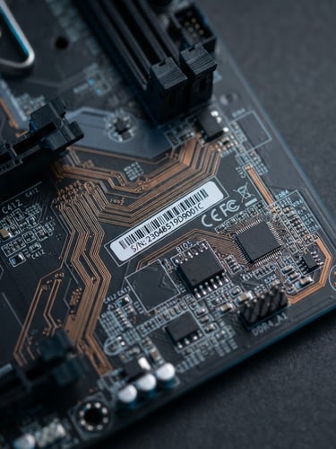 Macro photograph of a clean motherboard circuit board, focus on copper traces and serial number, anti-static blue lighting, dark gray background