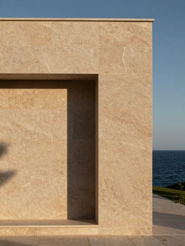 A close-up architectural elevation of a minimalist villa facade in Croatia, constructed from warm textured limestone of Brač, casting sharp geometric shadows under soft morning Mediterranean light, with a sliver of deep Adriatic navy sea visible on the right edge.