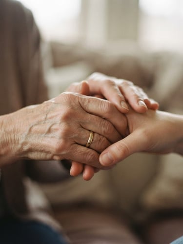 Warm editorial photography of two hands clasped in a supportive gesture, soft diffused natural light, muted compassionate tones, shallow depth of field, 35mm