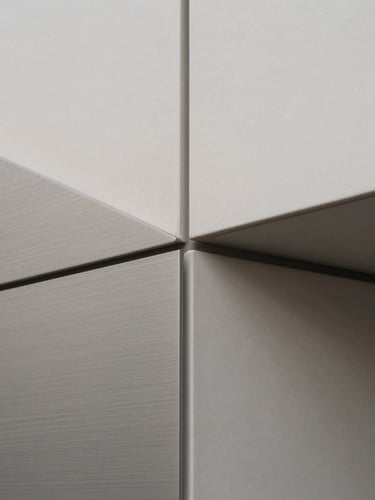 Close-up of brushed steel and matte ceramic textures, arranged geometrically, natural diffused daylight, high contrast, sharp focus.