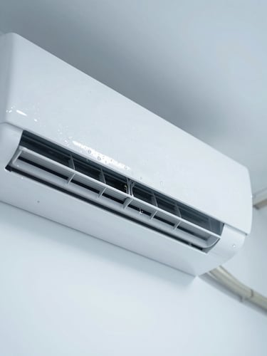 Close-up of a modern white wall-mounted air conditioning unit being serviced, clean water droplets, bright daylight, cool blue undertones, sharp focus