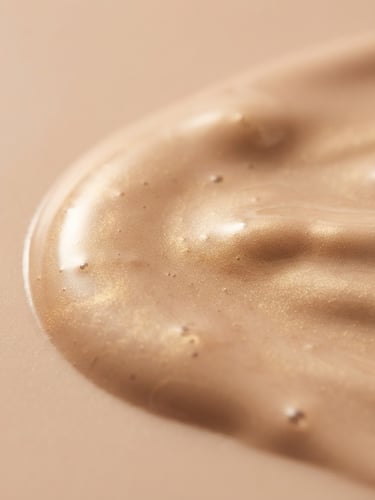 Macro shot of pristine liquid foundation texture with soft golden highlights, premium beauty product photography, soft diffused studio light
