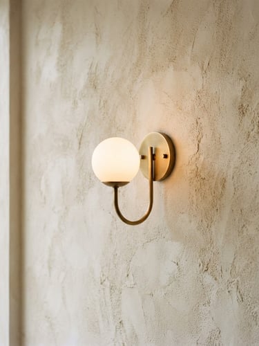 Warm minimalist lighting fixture casting soft shadows on a textured off-white plaster wall, natural side-lighting, elegant editorial photography