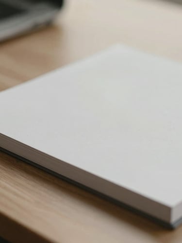 Macro detail of a clean technical document on a wooden desk, soft diffused overcast daylight, muted slate and cream tones.