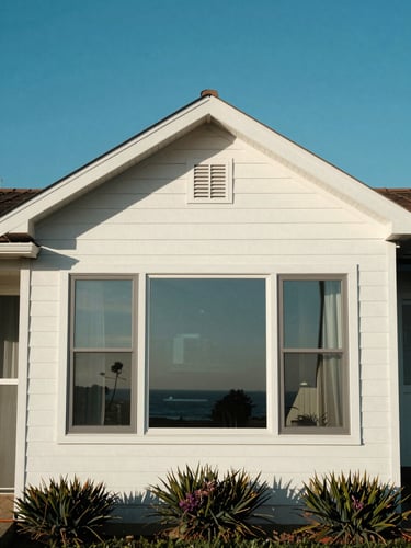 A beautiful sun-drenched coastal home in Orange County with sparkling clean windows reflecting a clear blue sky.