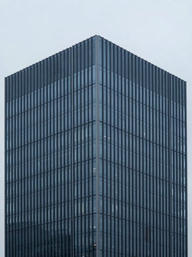 Minimalist architectural photography of a modern high-end corporate headquarters in cool overcast daylight, desaturated blue and charcoal tones, sharp focus, architectural wide-angle