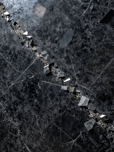 Extreme close-up of a raw dark quartzite slab with deep crystalline veins, polished surface reflecting sharp studio light, architectural minimalist aesthetic.